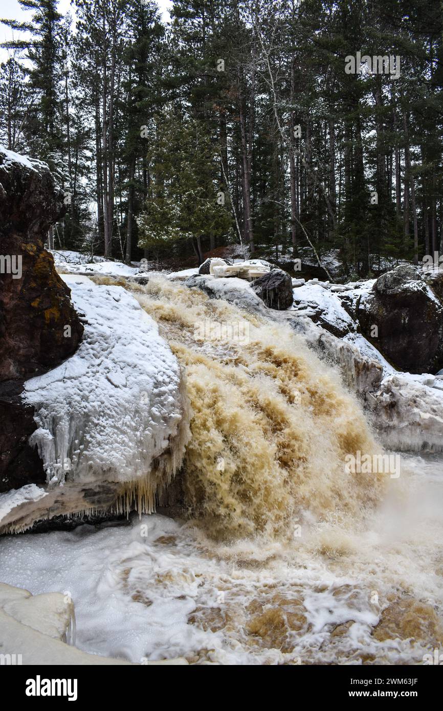 Una breve cascata infuria in un paesaggio ghiacciato Foto Stock