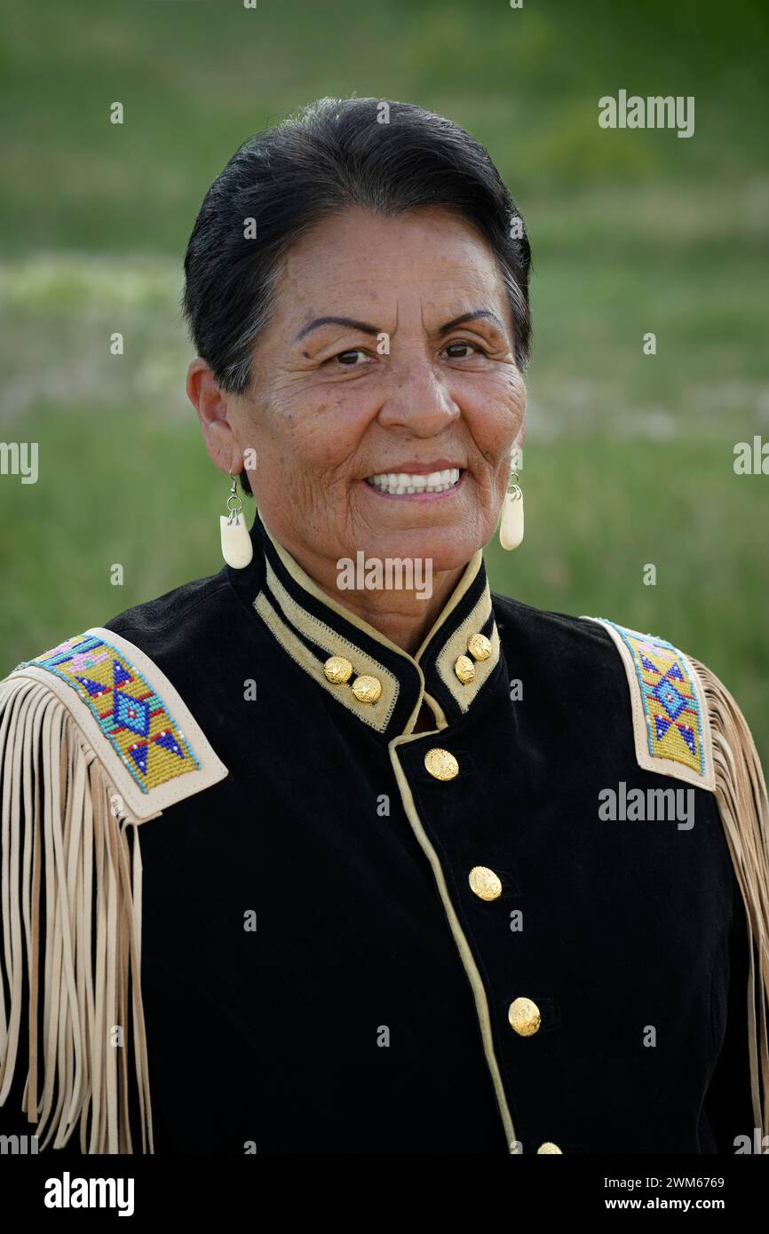 Marian Sorace (Sicangu Lakota Oyate) indossa le sue regalia da cappotto militare. Badlands National Park, South Dakota. Foto Stock
