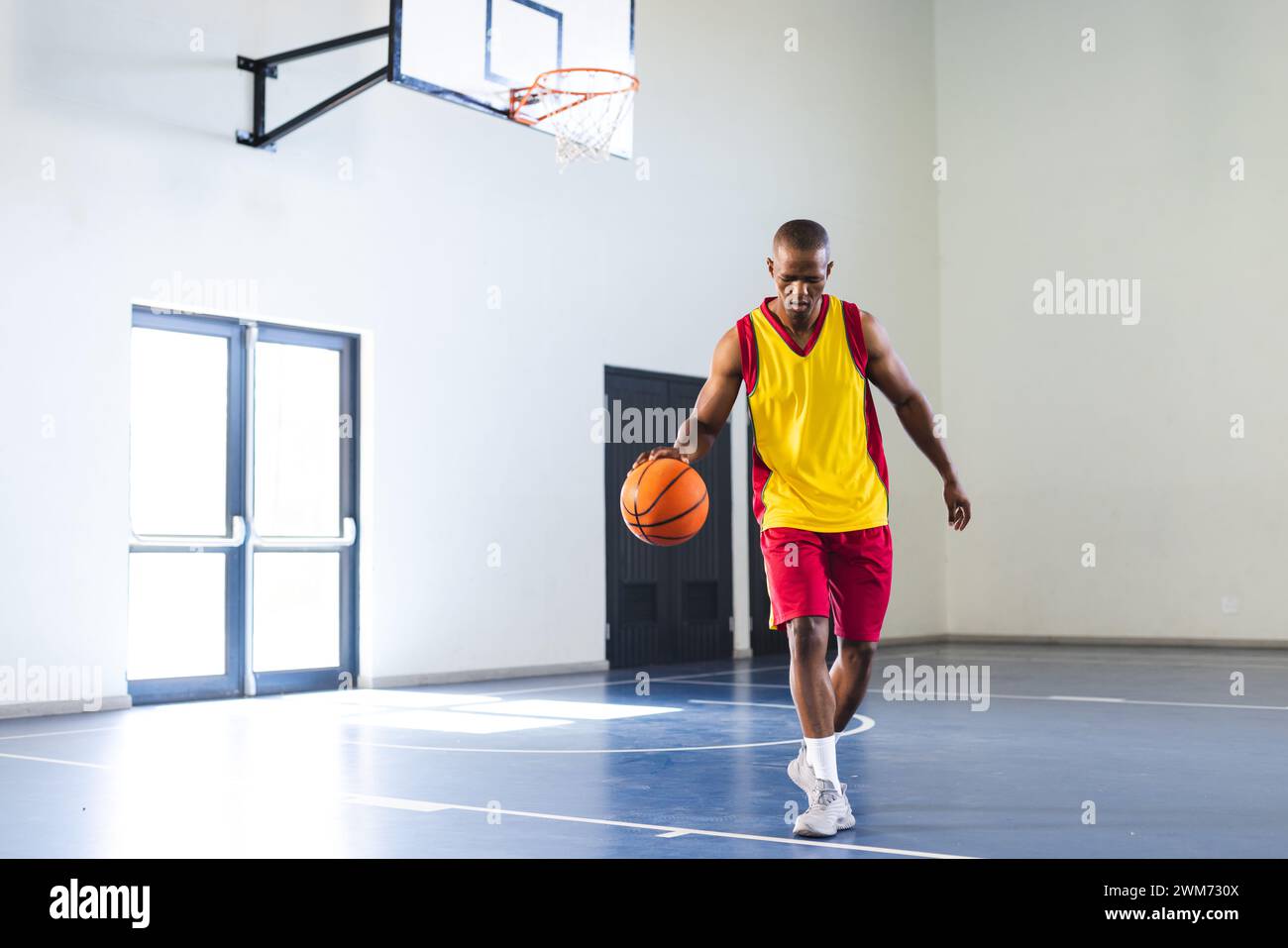 L'uomo afroamericano gioca a basket al chiuso, con spazio per copie Foto Stock
