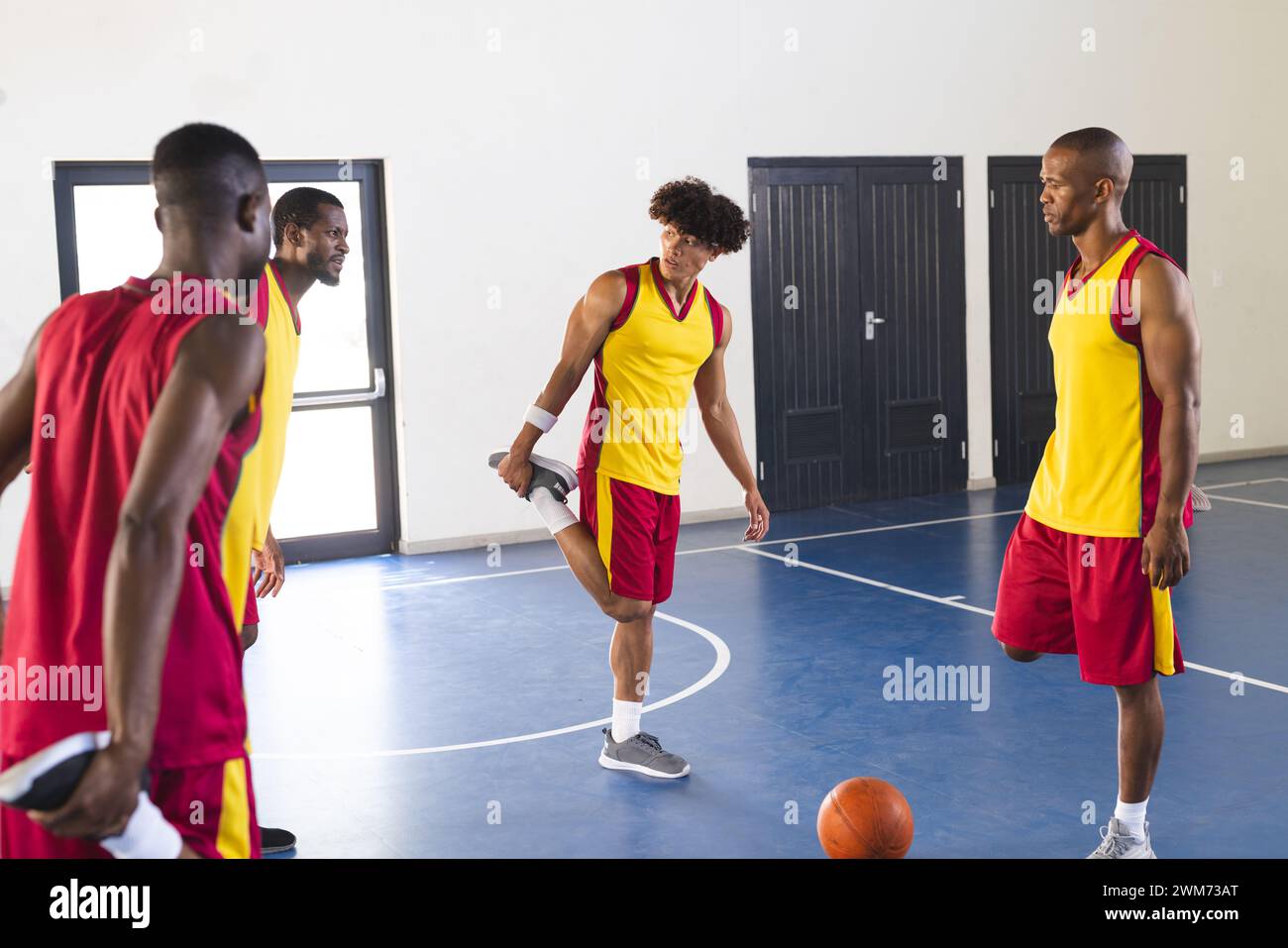 Gli uomini afroamericani e birazziali giocano a basket al chiuso Foto Stock