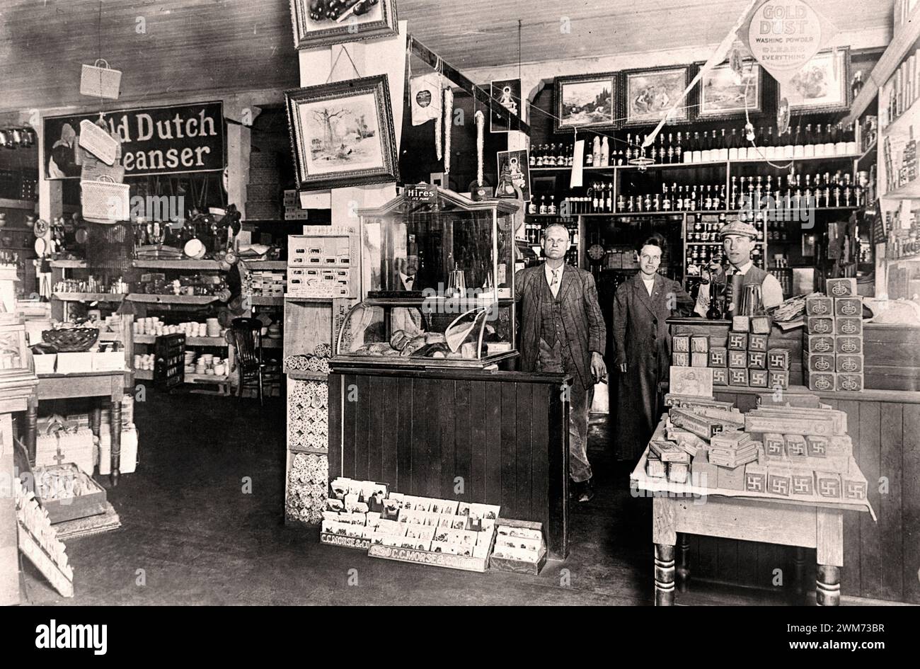 Stati Uniti Mill Valley interno del negozio di alimentari Wheeler Martin nel 1900 tre uomini si trovano dietro il bancone all'interno del negozio di alimentari Wheeler Martin al 106 di Throckmorton Avenue. Notare il simbolo della svastica sui pacchetti sul tavolo; questi sono della Pacific Coast Biscuit Company. Nei primi anni '1900, l'azienda utilizzò questo simbolo nel suo marketing. A quel tempo, negli stati del Pacifico, questo simbolo era destinato a trasmettere un senso di bontà. Foto Stock