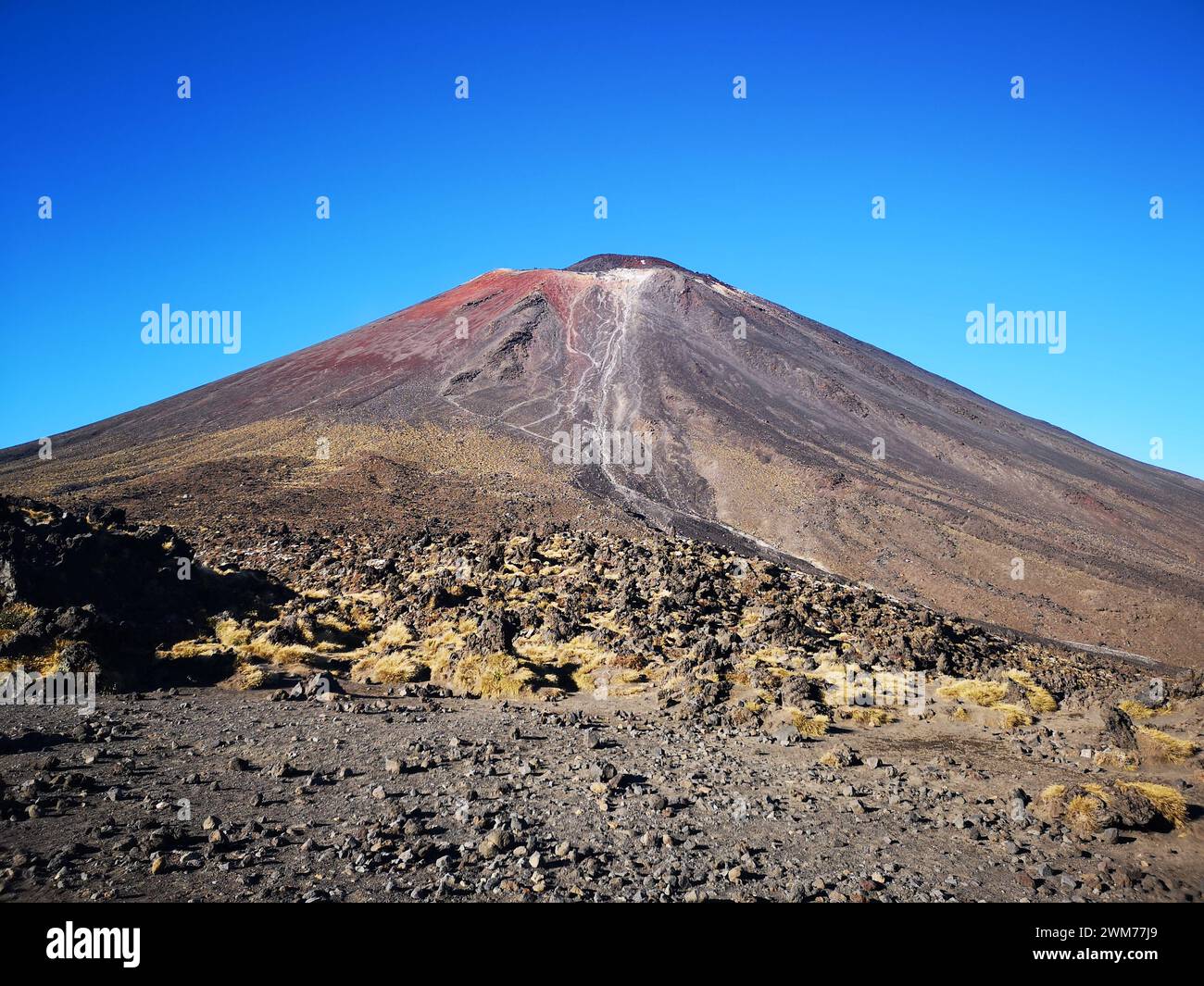 Vulcano con suolo rosso e verde in una giornata di sole Foto Stock