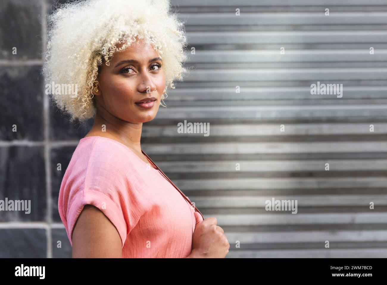 La giovane donna birazziale si trova con sicurezza all'aperto in città, con spazio per le copie Foto Stock