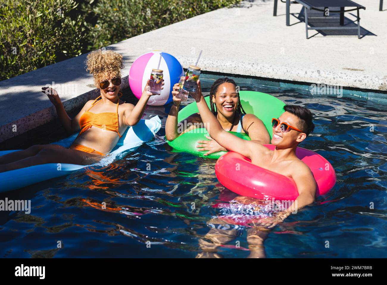 Gli amici trascorrono una giornata di sole in piscina Foto Stock
