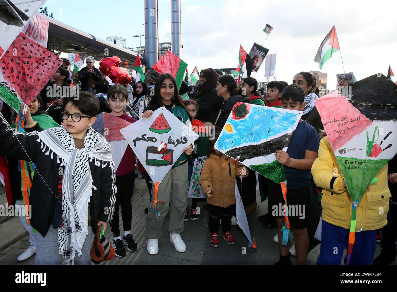 Salford, Regno Unito. 24 febbraio 2024. Centinaia di famiglie si riuniscono con i loro figli per protestare contro la BBC e la notizia "parziale" del bombardamento della Palestina. I manifestanti hanno chiesto una Palestina libera e il cessate il fuoco. I bambini hanno tenuto gli aquiloni in solidarietà con i bambini della striscia di Gaza che detengono il guiness book of record per il maggior numero di aquiloni volati contemporaneamente. I bambini hanno anche bambole bendate e fatto manifesti insieme lasciando una pila di scarpe per bambini per rappresentare i bambini uccisi a Gaza. Media City, Salford, Regno Unito. Crediti: Barbara Cook/Alamy Live News Foto Stock