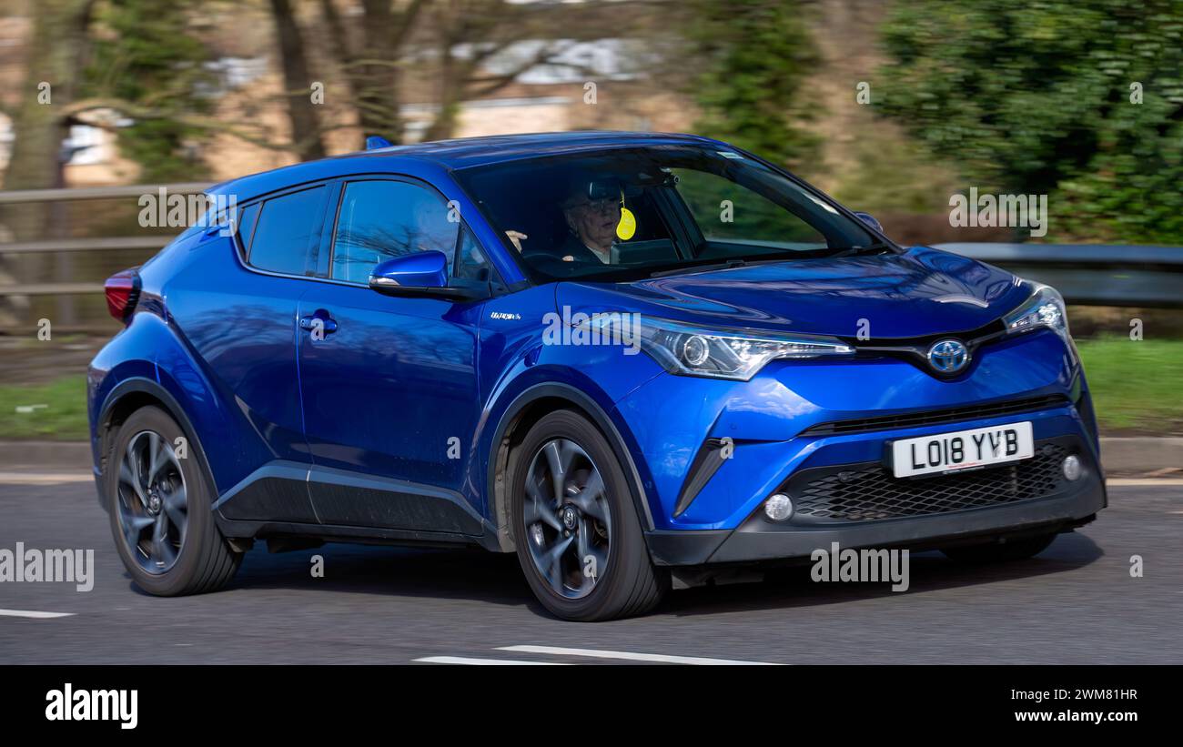 Milton Keynes, UK-24 febbraio 2024: 2018 auto elettrica ibrida Toyota C-HR blu che guida su una strada inglese Foto Stock
