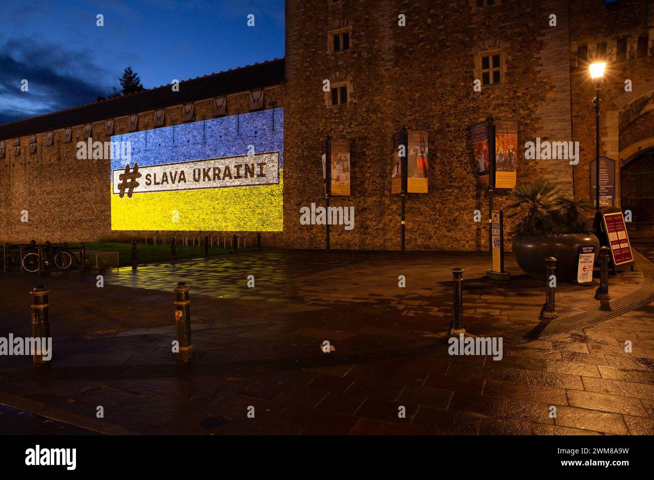 Il castello di Cardiff è illuminato dalla bandiera Ucraina e dalle parole "#Slava Ukraini" (gloria all'Ucraina! Gloria agli eroi) sabato 24 febbraio 2024, per dimostrare sostegno all'Ucraina in occasione dell'anniversario dell'invasione dell'Ucraina da parte delle forze russe.gli edifici nel Regno Unito e nel mondo si illuminano con i colori ucraini, inviando un messaggio di continuo sostegno del Regno Unito al popolo ucraino. In alcuni edifici saranno inoltre presenti le parole "Slava Ukraini” che si traduce in "Gloria all'Ucraina”. È un saluto nazionale ucraino, noto come simbolo della sovranità Ucraina e della resistenza alla Russia Foto Stock