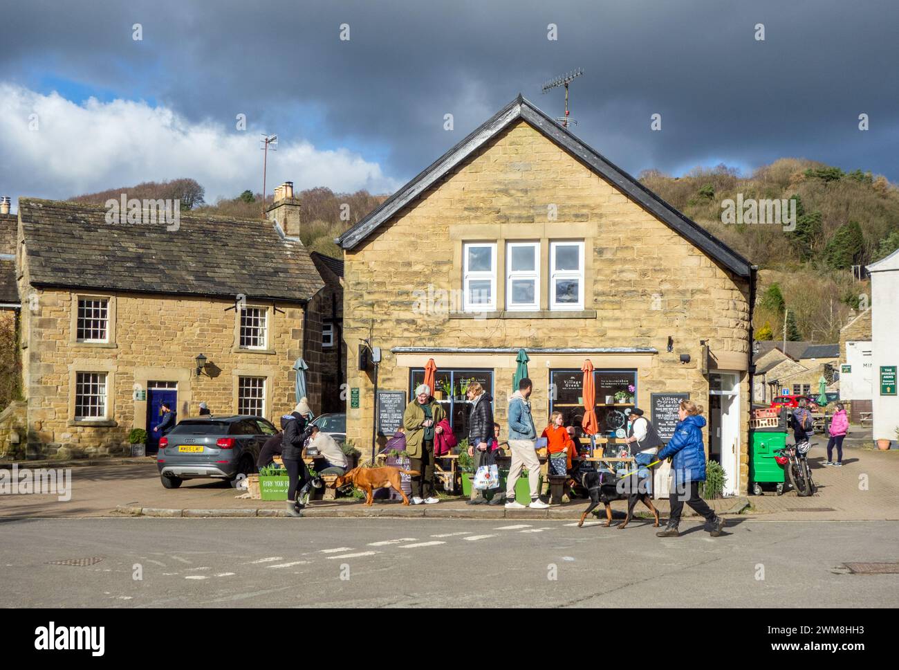 Persone fuori caffè che mangiano e bevono nel villaggio della peste del Derbyshire di Eyam Foto Stock