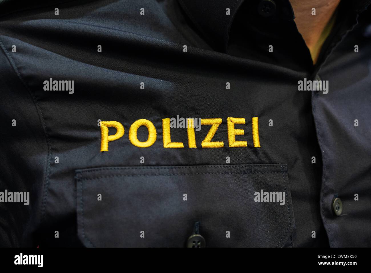 Augusta, Baviera, Germania - 2 febbraio 2024: Primo piano di lettere della polizia sull'uniforme di un ufficiale di polizia alla fiera AFA di Augusta *** Nahaufnahme von einem Polizei Schriftzug auf der Uniform von einem Polizisten auf der AFA Messe ad Augusta Foto Stock