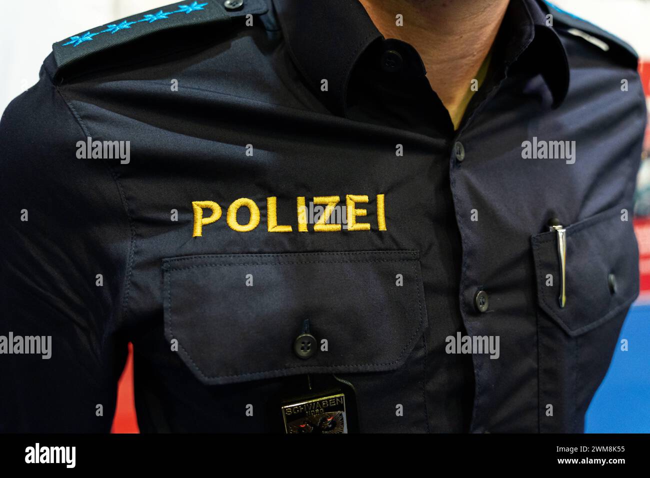 Augusta, Baviera, Germania - 2 febbraio 2024: Primo piano di lettere della polizia sull'uniforme di un ufficiale di polizia alla fiera AFA di Augusta *** Nahaufnahme von einem Polizei Schriftzug auf der Uniform von einem Polizisten auf der AFA Messe ad Augusta Foto Stock