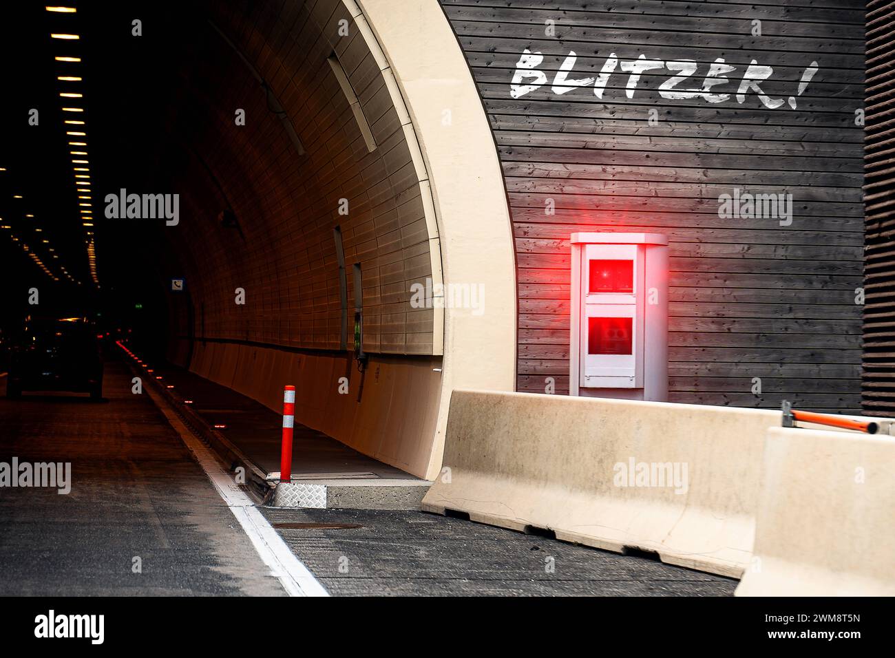 24 febbraio 2024: Lettere autovelox sopra una trappola di velocità a luce rossa accanto a un tunnel sull'autostrada. FOTOMONTAGGIO *** Blitzer Schriftzug über einer Rotlicht Radarfalle neben einem Tunnel auf der Autobahn. FOTOMONTAGE Foto Stock