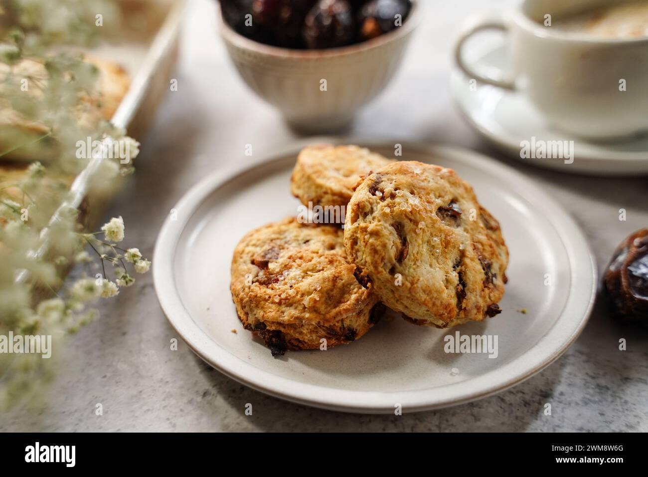 Scones fatti in casa serviti con una tazza di caffè e frutta fresca Foto Stock