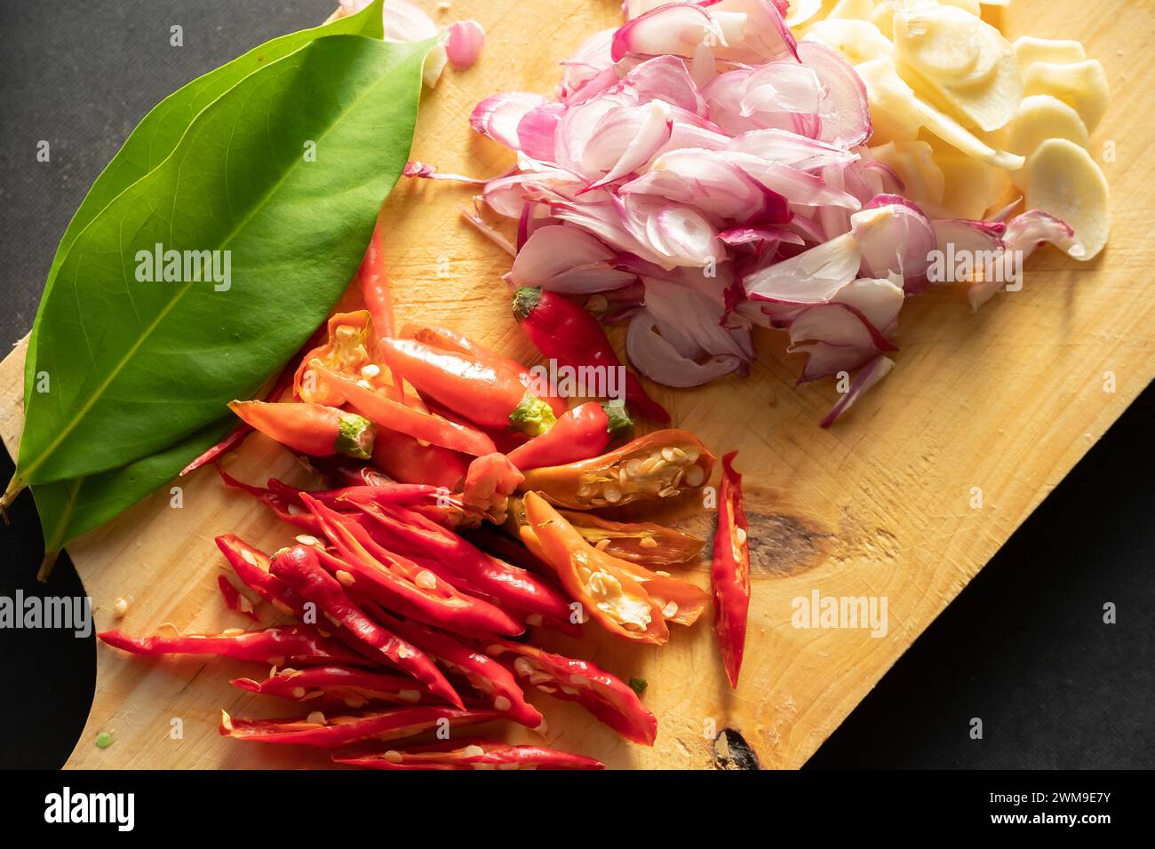 ​​hot peperoncini rossi e scalogni a fette su un tagliere Foto Stock