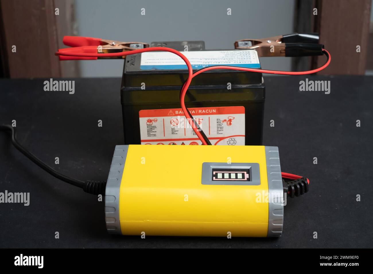 Ricarica della batteria della motocicletta, manutenzione della batteria e concetto di riparazione Foto Stock