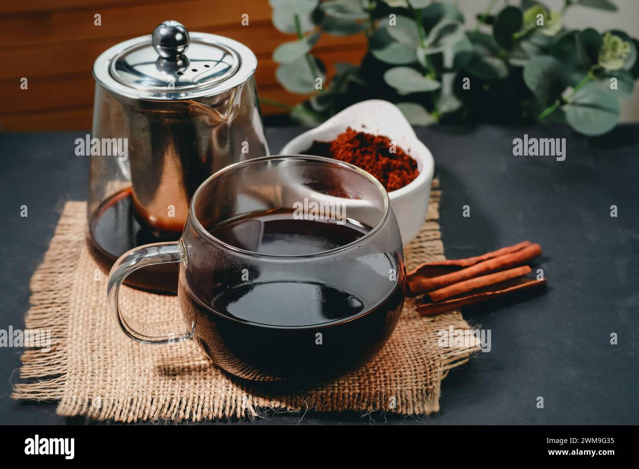 Caffè nero e bastoncini di cannella. Caffè aromatico proveniente da fondi di caffè appena macinati. Foto Stock