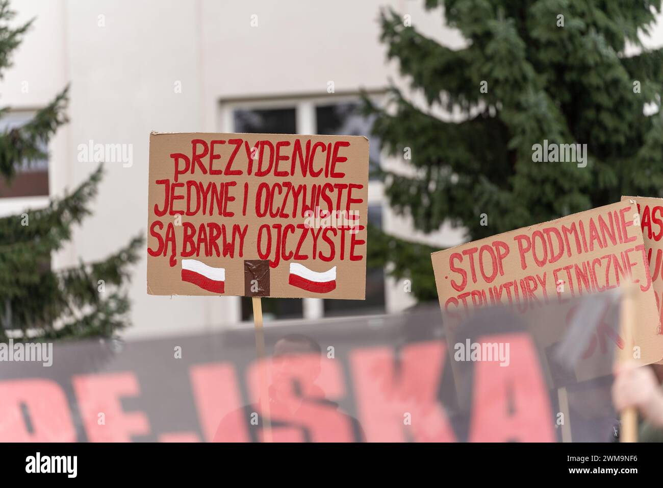 Varsavia, Polonia. 24 febbraio 2024. Un manifestante tiene un cartello che esprime la sua opinione in mezzo alla folla durante la manifestazione. La Konfederacja Korony Polskiej (Confederazione della Corona polacca) (partito di estrema destra polacco) organizzò una protesta contro il patto di delocalizzazione dei migranti dell'Unione europea. Durante la manifestazione, la folla ha cantato slogan anti-ucraini, anti-europei e anti-immigrati. (Foto di Marek Antoni Iwa?czuk/SOPA Images/Sipa USA) credito: SIPA USA/Alamy Live News Foto Stock