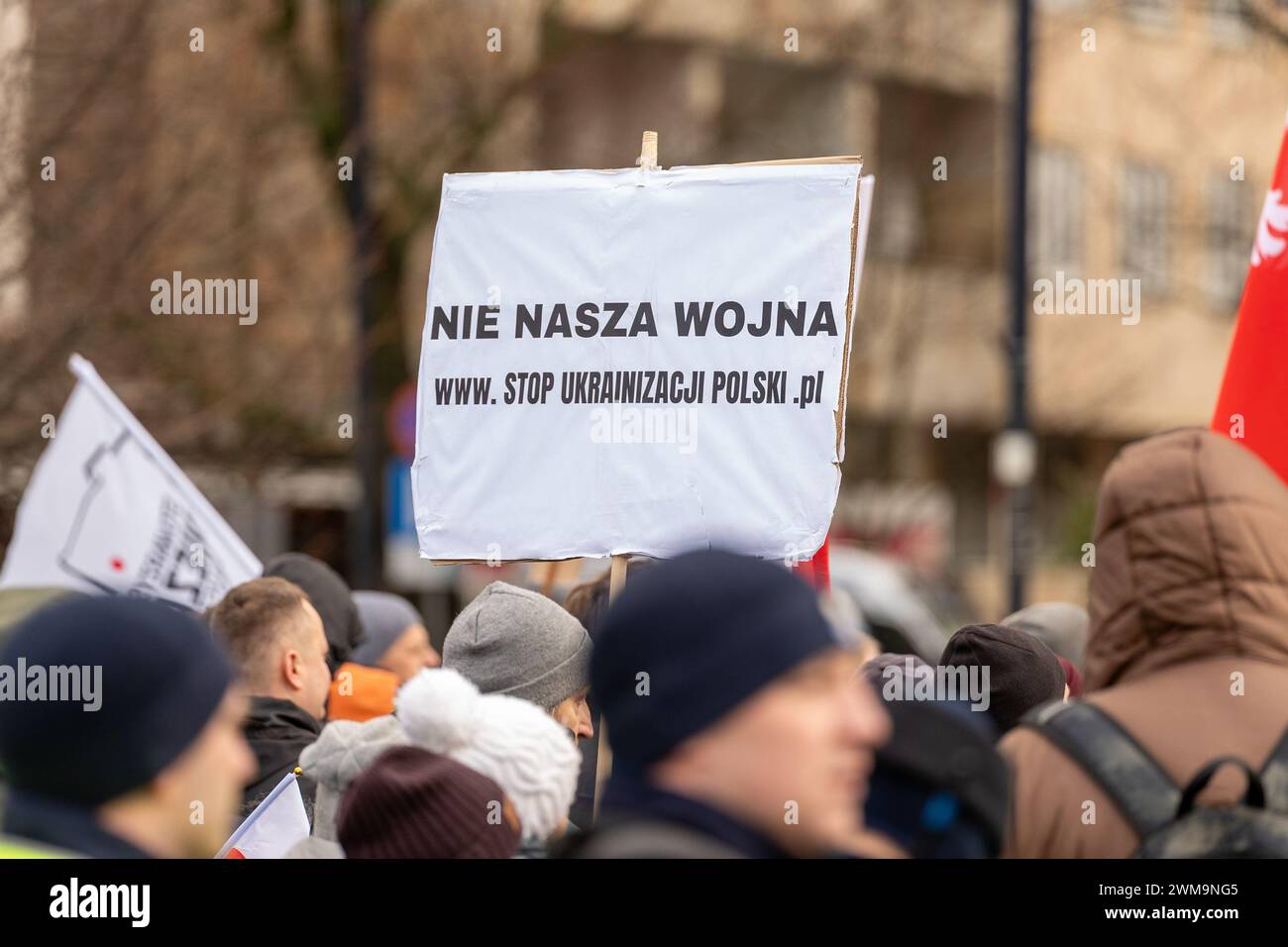 Varsavia, Polonia. 24 febbraio 2024. Un manifestante tiene un cartello che esprime la sua opinione in mezzo alla folla durante la manifestazione. La Konfederacja Korony Polskiej (Confederazione della Corona polacca) (partito di estrema destra polacco) organizzò una protesta contro il patto di delocalizzazione dei migranti dell'Unione europea. Durante la manifestazione, la folla ha cantato slogan anti-ucraini, anti-europei e anti-immigrati. (Foto di Marek Antoni Iwa?czuk/SOPA Images/Sipa USA) credito: SIPA USA/Alamy Live News Foto Stock