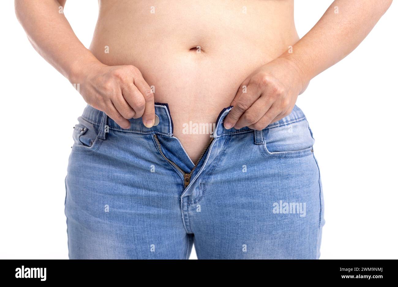 Donna grassa che cerca di indossare jeans Foto Stock