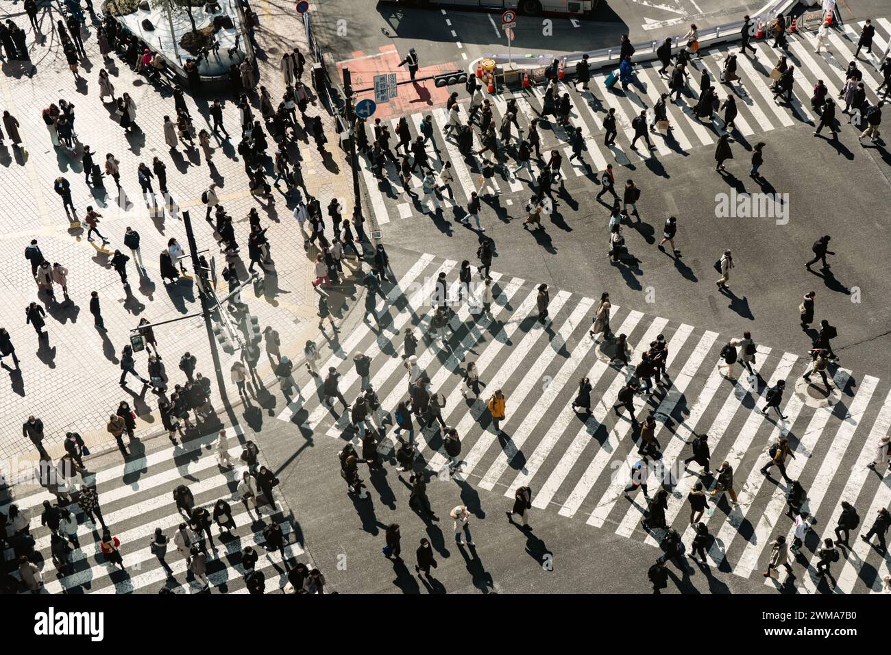 Persone che attraversano la strada a Shibuya, attraversando il Giappone. Il testo giapponese sul cartello stradale significa stazione di Shibuya e attraversamento a breve termine. Foto Stock