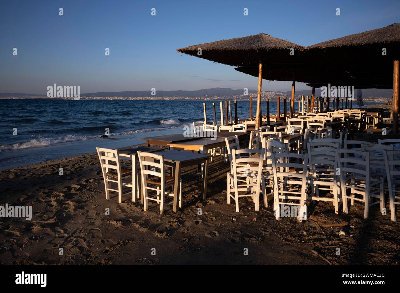 Tavoli, sedie, impilati, ombrelloni, bar sulla spiaggia, vuoto, spiaggia, mare, Peraia, anche Perea, luce serale, Salonicco, Macedonia, Grecia Foto Stock