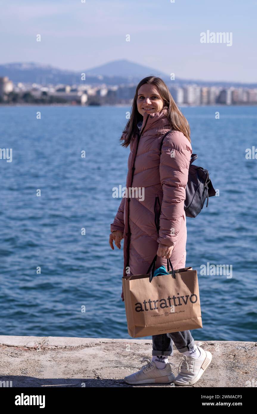 Giovane donna, cappotto, shopping bag, shopping, mare, porto vecchio, Salonicco, Macedonia, Grecia Foto Stock