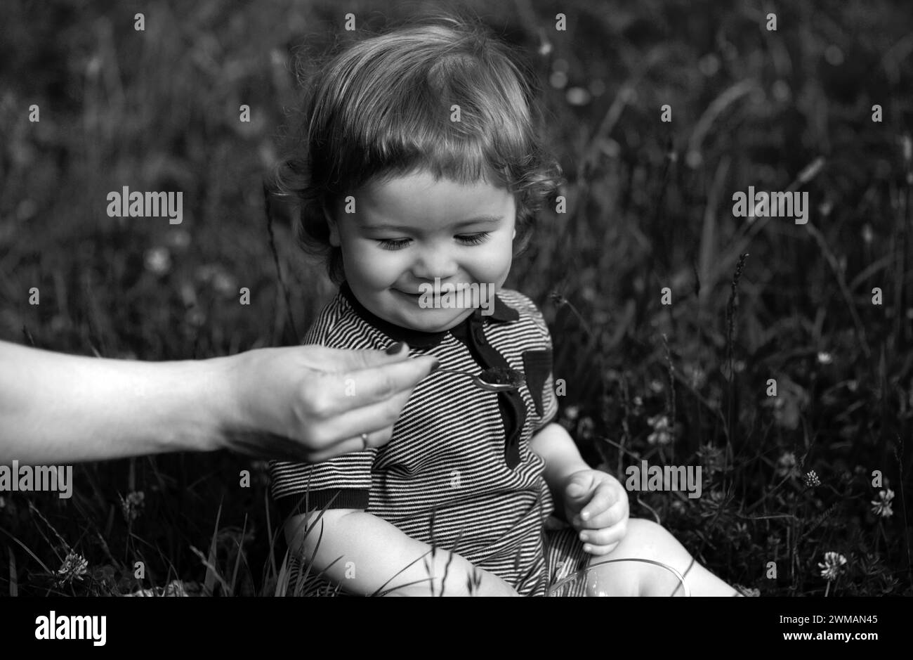 Famiglia, cibo, bambino, mangiare e genitorialità concetto. Madri che allattano a mano il bambino con un cucchiaio. Cucchiaino per nutrire il bambino. Foto Stock