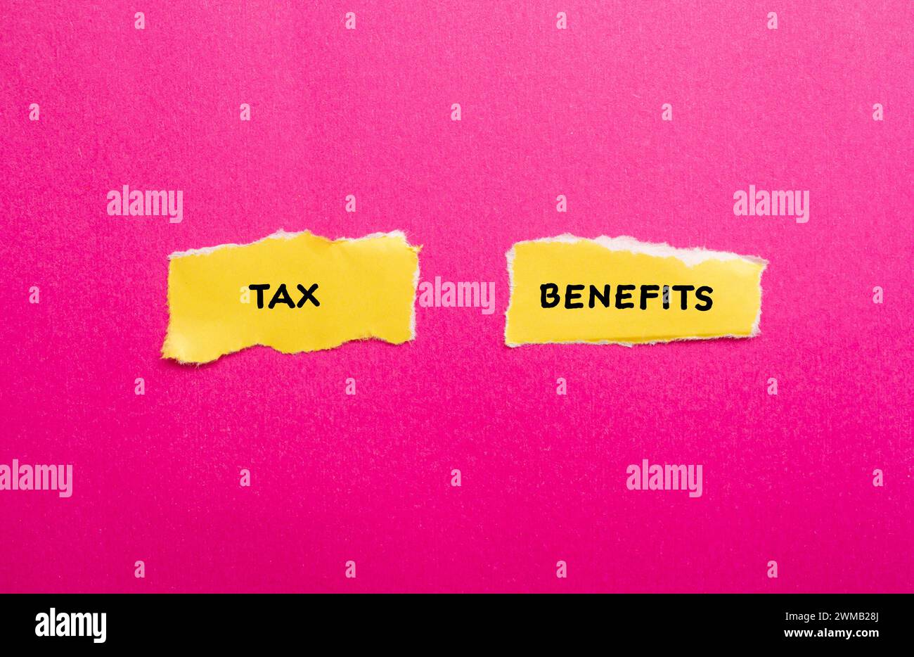Parole sulle agevolazioni fiscali scritte su pezzi di carta strappati di colore giallo con sfondo rosa. Simbolo commerciale concettuale. Copia spazio. Foto Stock