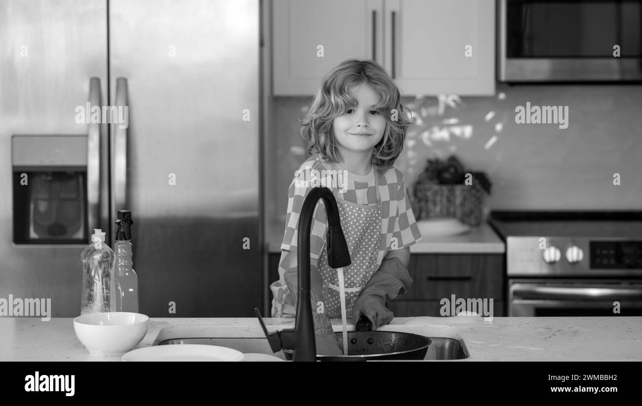 Concetto di lavaggio delle stoviglie. Bambini che fanno e pulendo piatti in cucina. Piccolo bambino che pulisce a casa. Bambino che fa il lavoro di casa che si diverte. Ragazzo carino aiutare Foto Stock