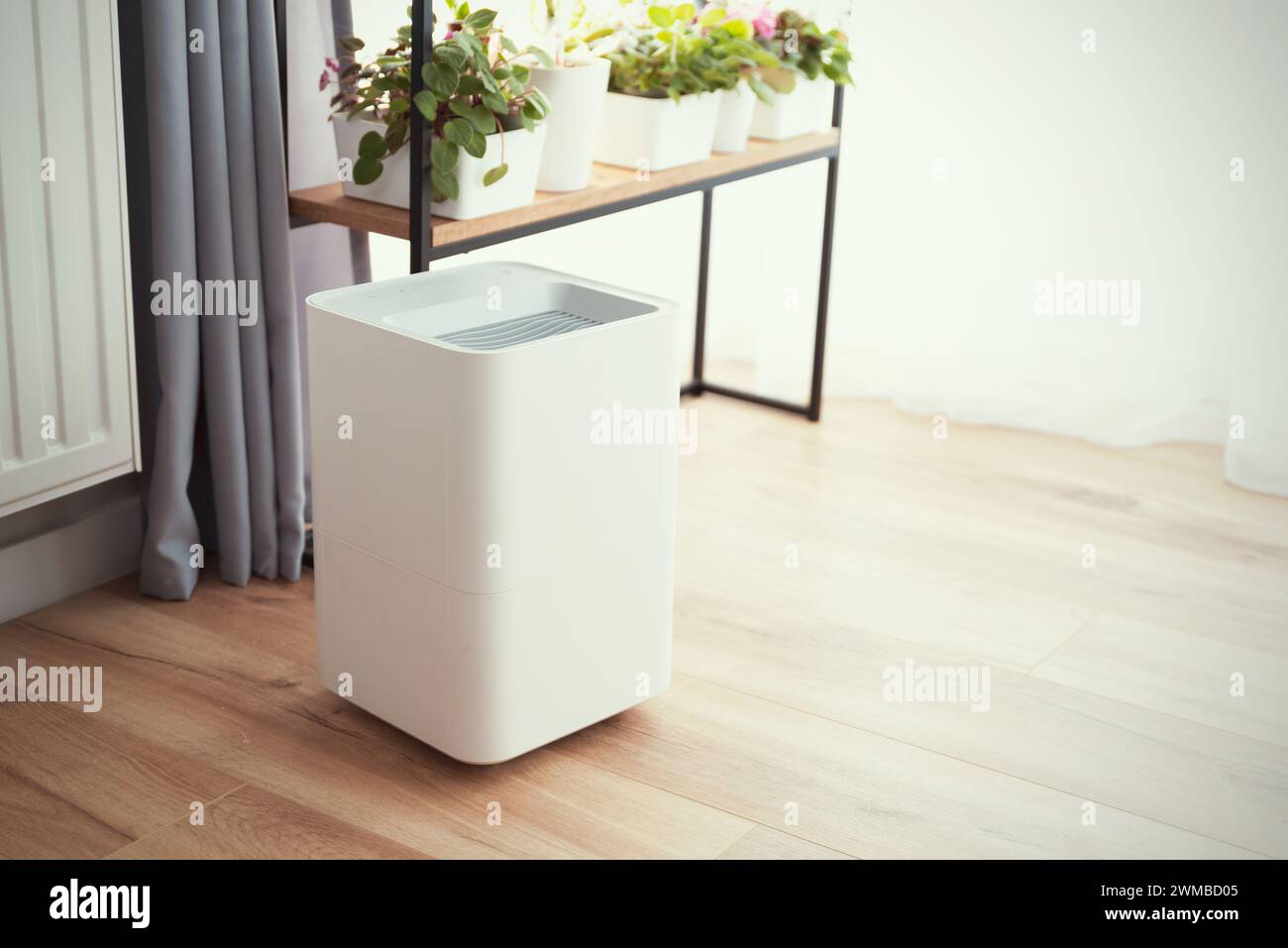 Moderno umidificatore d'aria sul pavimento nel soggiorno. Concetto di assistenza sanitaria Foto Stock