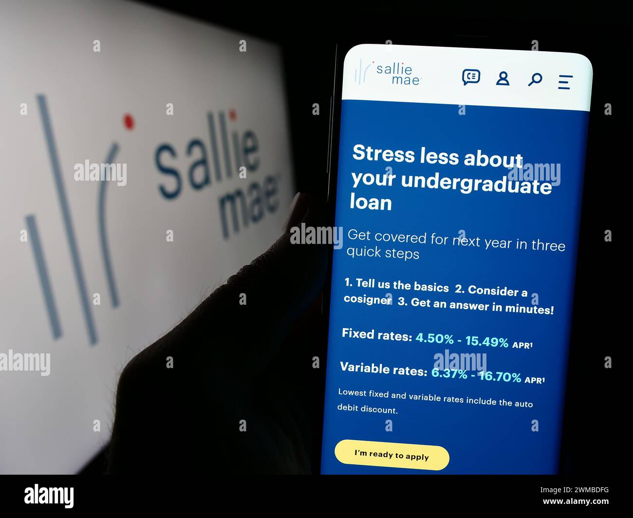 Persona che detiene un cellulare con pagina web della società finanziaria americana SLM Corporation (Sallie Mae) davanti al logo. Messa a fuoco al centro del display del telefono. Foto Stock
