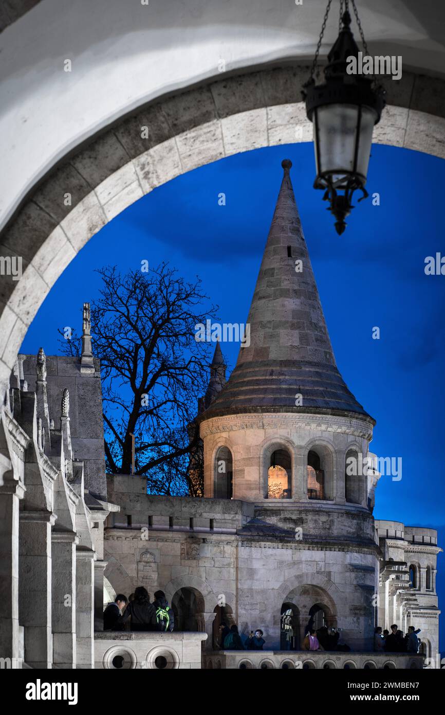 Budapest, Ungheria - 16 aprile 2023: Arco del Bastione dei pescatori con la torre del bastione sullo sfondo durante l'ora blu serale Foto Stock