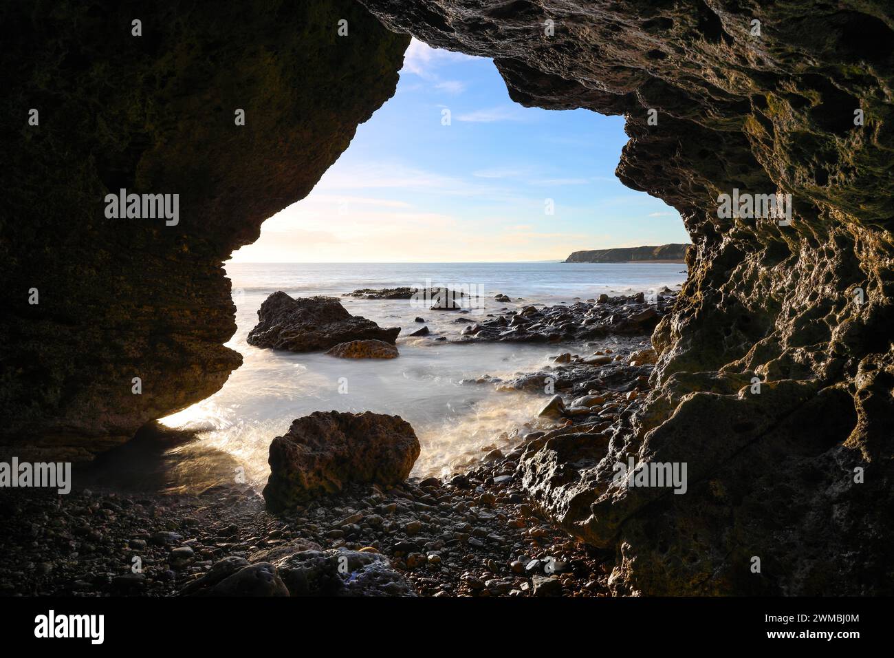 Vista da una grotta marina sulla spiaggia di Seaham Blast all'alba, Durham Heritage Coast, Seaham, County Durham, Regno Unito Foto Stock