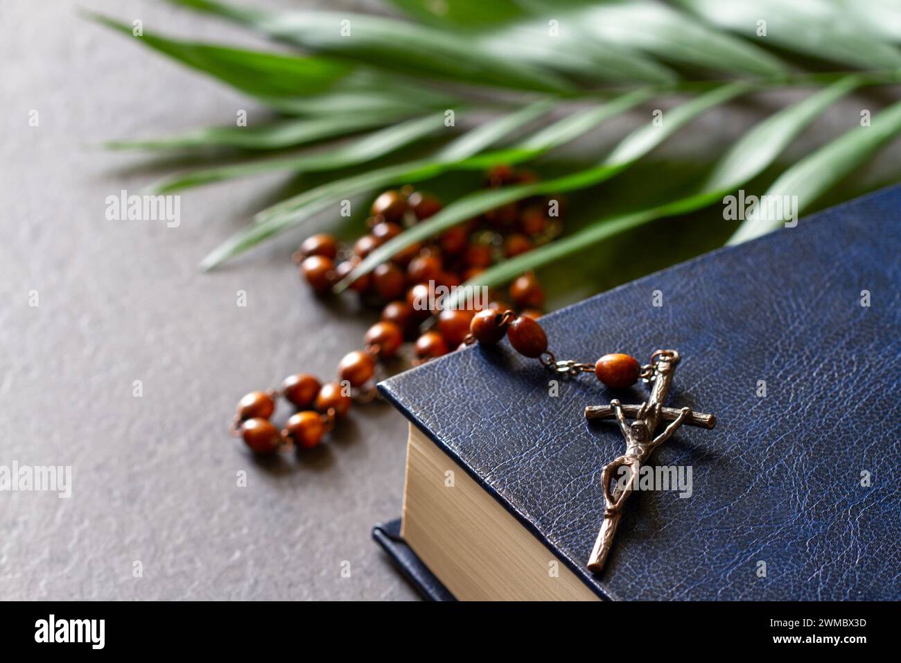 Bibbia con rosario e ramo di palma. Concetto religioso della domenica delle Palme Foto Stock