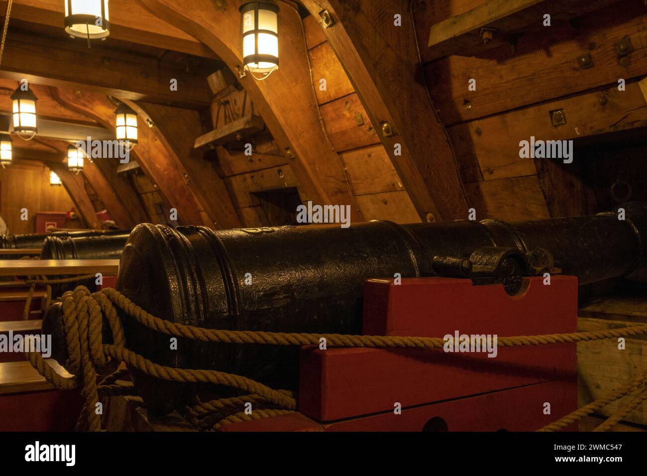 Vecchio cannone all'interno di una nave d'epoca, pistola vecchio stile, arma con lanterne, fotografia orizzontale Foto Stock