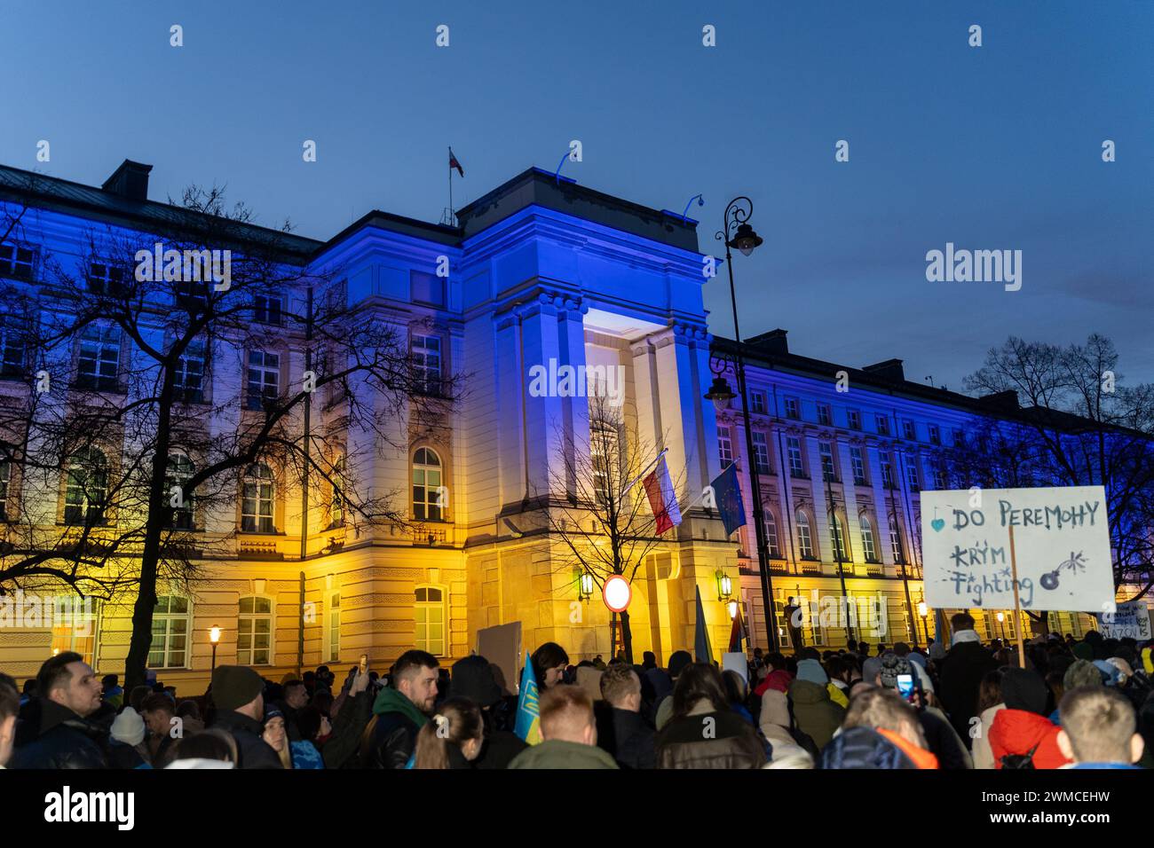 Varsavia, Polonia. 24 febbraio 2024. I manifestanti marciano davanti alla cancelleria del primo ministro della Polonia, illuminata nei colori della bandiera nazionale dell'Ucraina a Varsavia. Migliaia di persone si sono radunate fuori dall'ambasciata della Federazione Russa a Varsavia e hanno marciato sul parlamento polacco mentre oggi segnano due anni di aggressione russa all'Ucraina. (Credit Image: © Marek Antoni Iwanczuk/SOPA Images via ZUMA Press Wire) SOLO PER USO EDITORIALE! Non per USO commerciale! Foto Stock