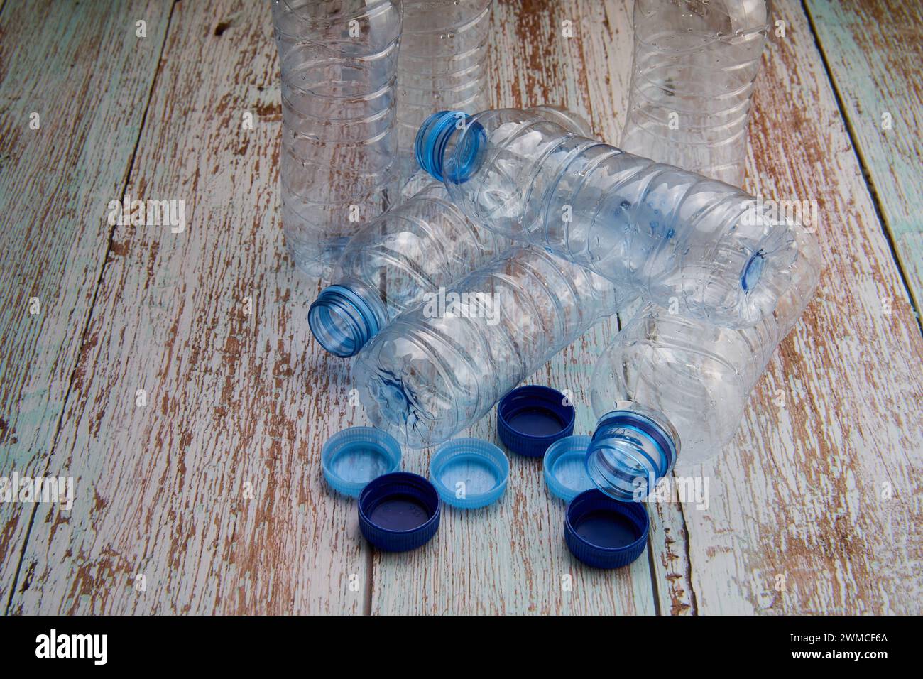 Vista dall'alto dei flaconi in plastica chiusi e aperti posizionati su un tavolo di legno per il riciclaggio. Foto Stock