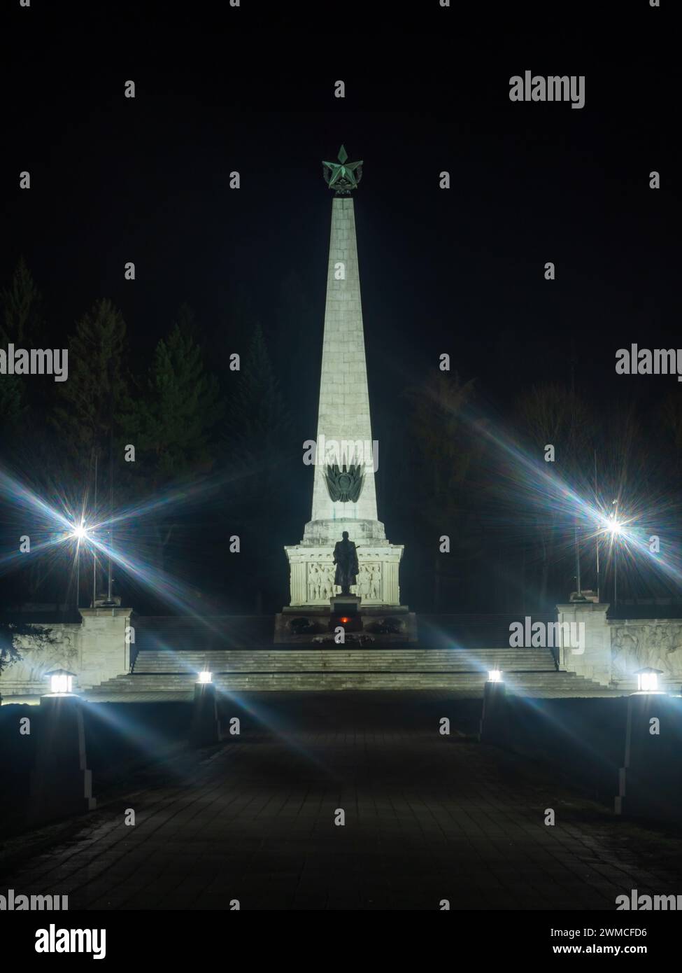 Commemorazione illuminata dell'esercito sovietico a Svidnik di notte con una scultura di un soldato in guardia. Slovacchia, Europa. Foto Stock