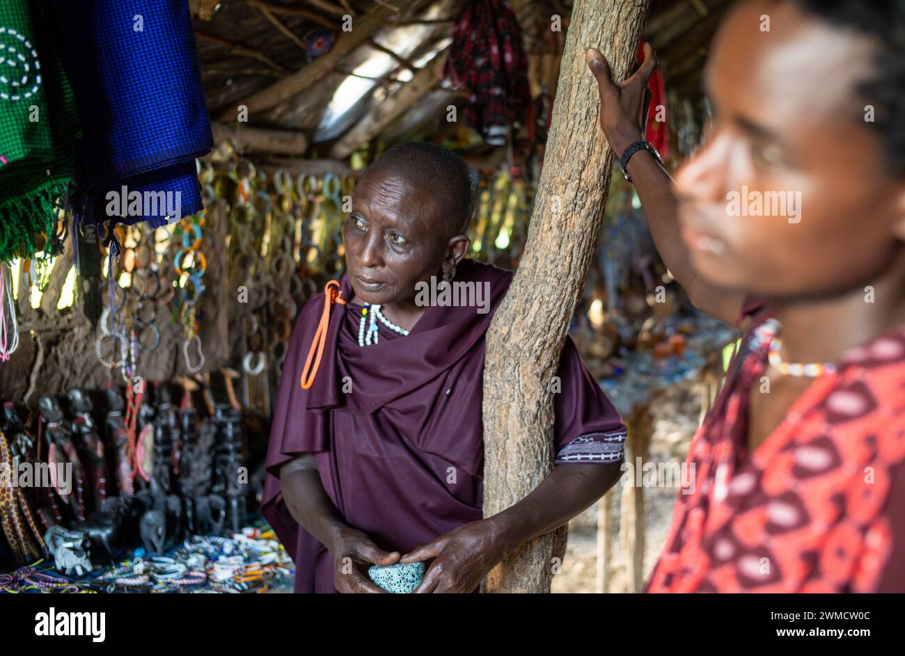 Una donna Maasai nella sua capanna dove vende souvenir a turisti stranieri a Mikumi, Tanzania Foto Stock