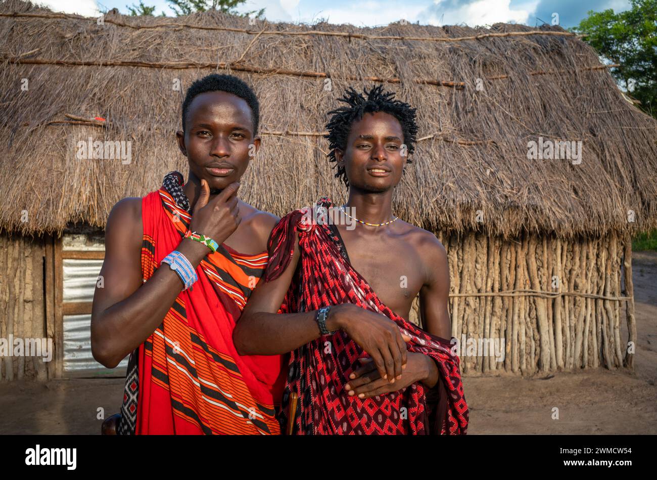 Due uomini guerrieri Maasai che indossano shukas nel loro villaggio di Mikumi, Tanzania Foto Stock