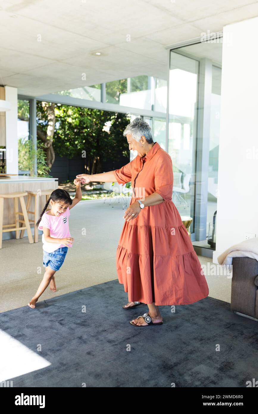La nonna birazziale balla con una nipote birazziale a casa Foto Stock