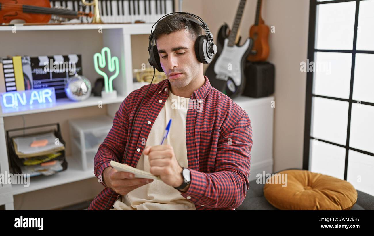 Nel cuore dello studio, giovane e affascinante ispanico, un appassionato artista musicale, che compose seriamente una canzone armoniosa, mettendo l'anima nei testi con V Foto Stock
