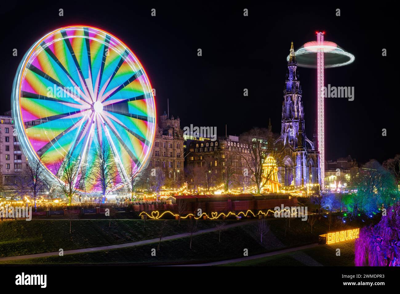 Le luci di Natale di Edimburgo con il monumento a Scott e la grande ruota panoramica Foto Stock