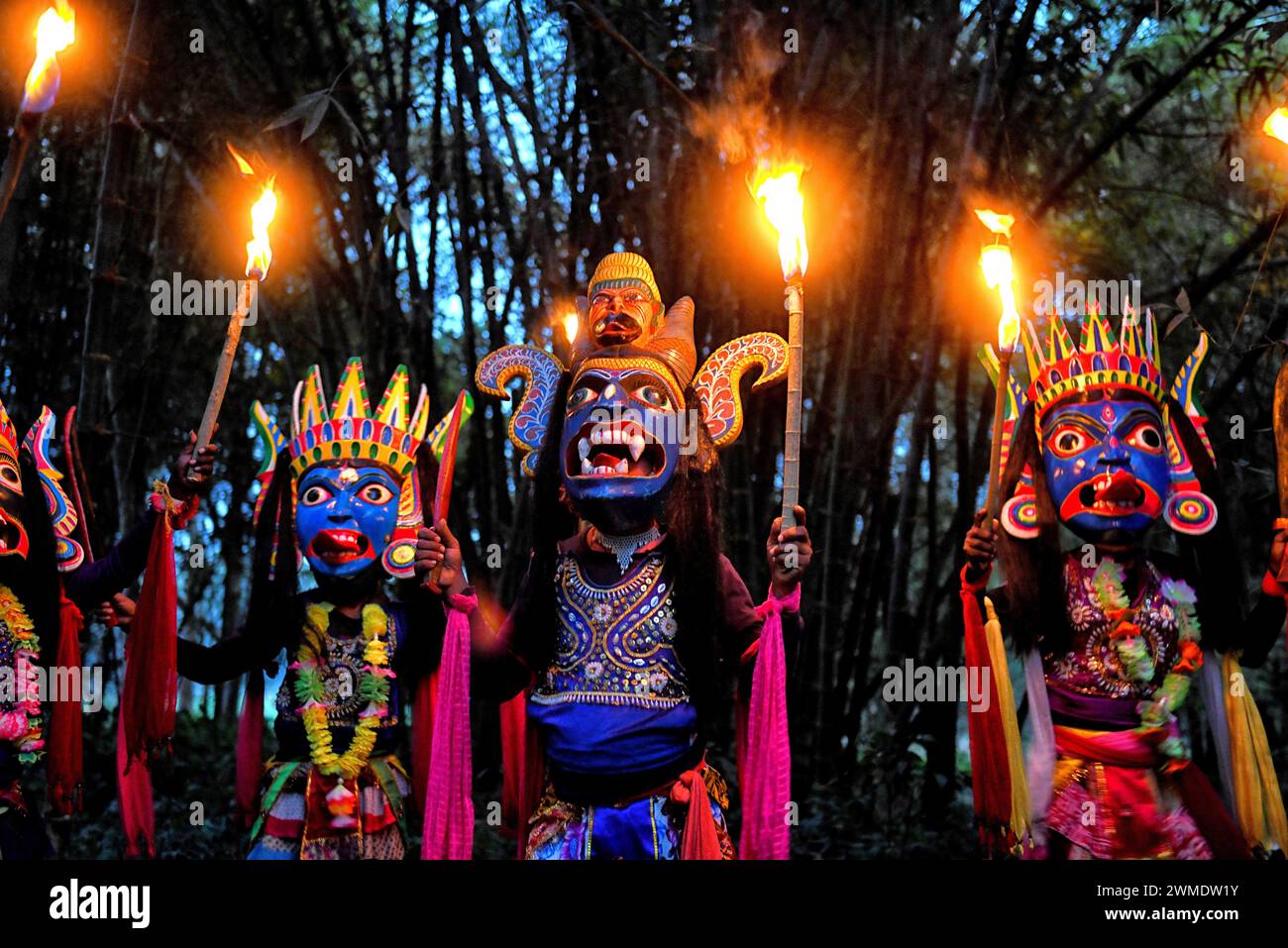 I ballerini mascherati della compagnia di danza Gomira tengono in mano torce brucianti durante lo spettacolo. Gomira è una forma di danza mascherata. La parola "Gomira" deriva dalla forma colloquiale della parola "Gram-Chandi" o la divinità femminile che è la forza protettiva del villaggio. L'origine esatta della forma di danza non è rintracciabile e la conoscenza è andata perduta nel tempo. La danza Gomira è una forma di danza rurale praticata principalmente nel distretto di Dinajpur nel Bengala Occidentale. Le danze di Gomira sono organizzate per placare la divinità per inaugurare le "forze buone" e cacciare le "forze malvagie". Di solito è organizzato durante la m. Foto Stock