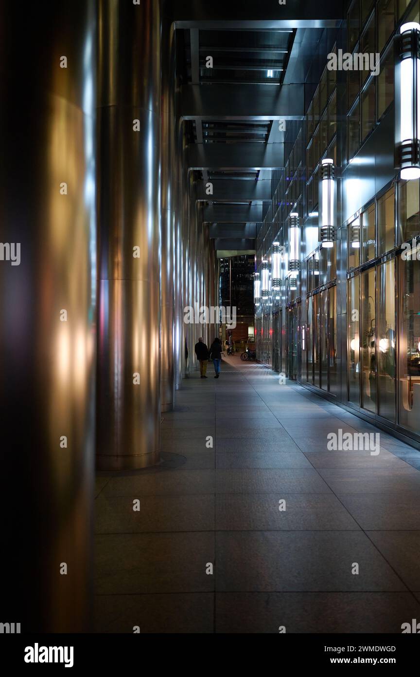 15 feb 2024 - londonuk: Vista notturna su marciapiede con colonne metalliche e facciata metallica dell'edificio a londra Foto Stock