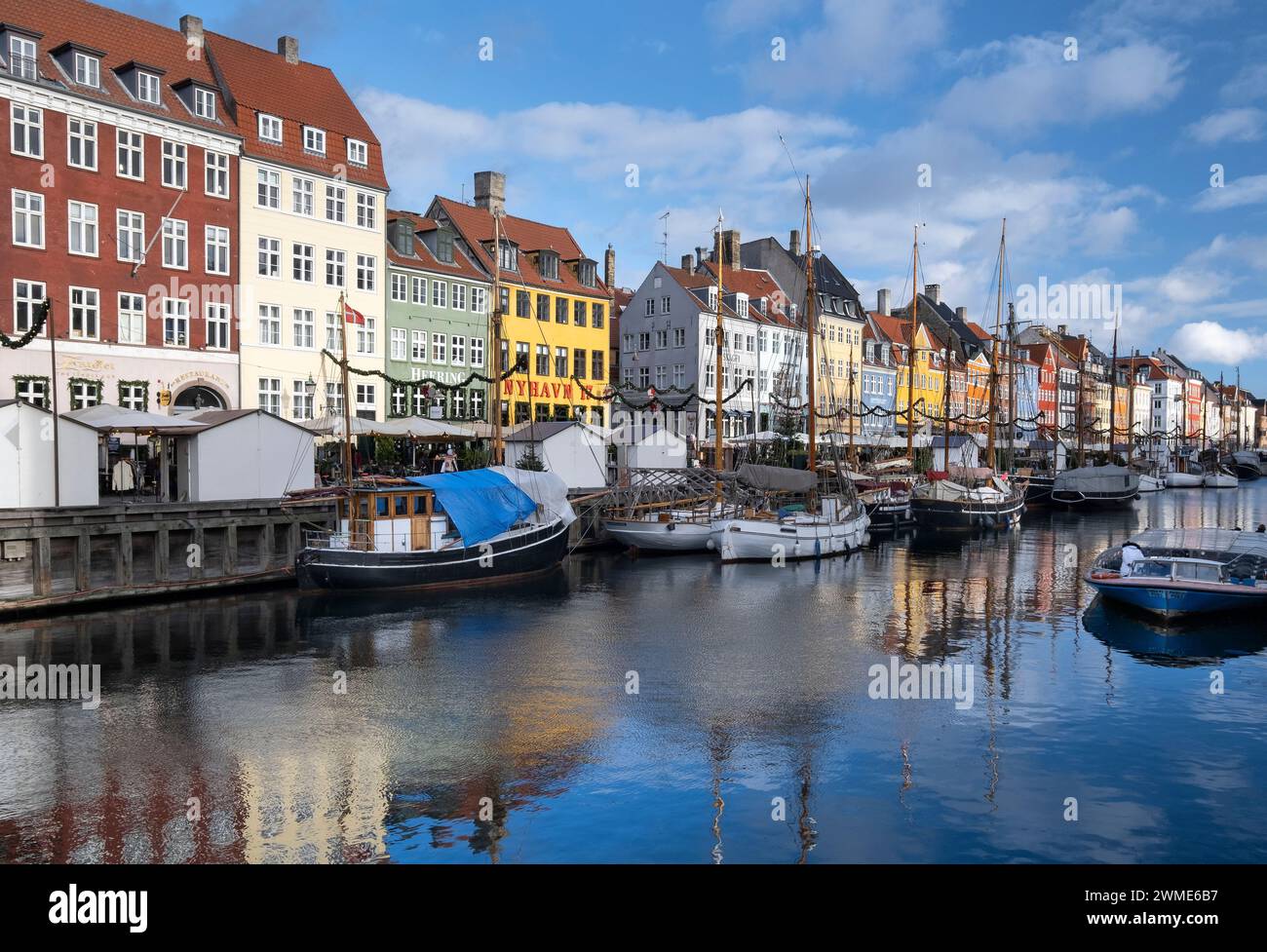 Edifici colorati e barche a alberi alti sul lungomare di Nyhavn, Copenhagen, Danimarca, Europa Foto Stock