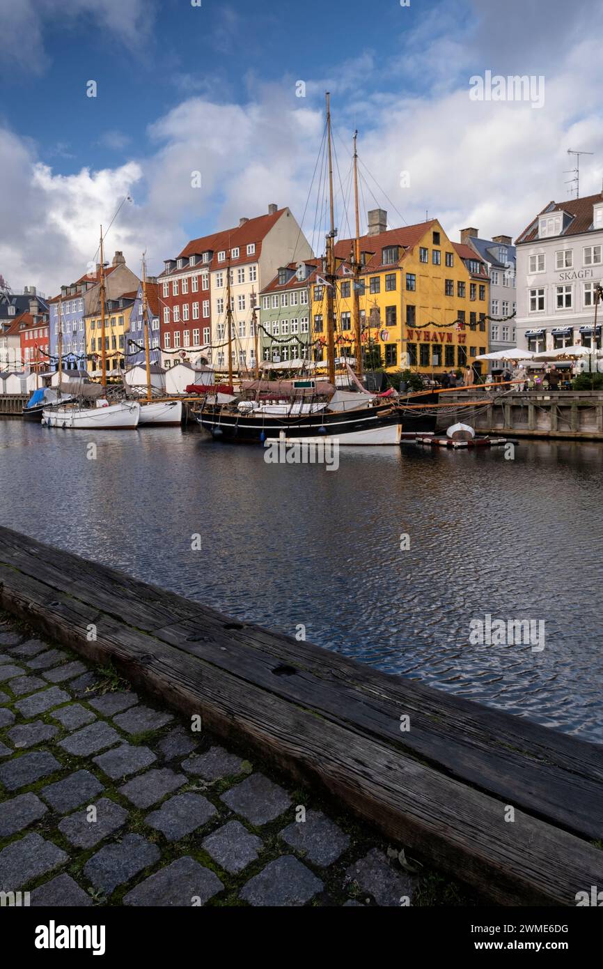 Edifici colorati e barche a alberi alti sul lungomare di Nyhavn, Copenhagen, Danimarca, Europa Foto Stock