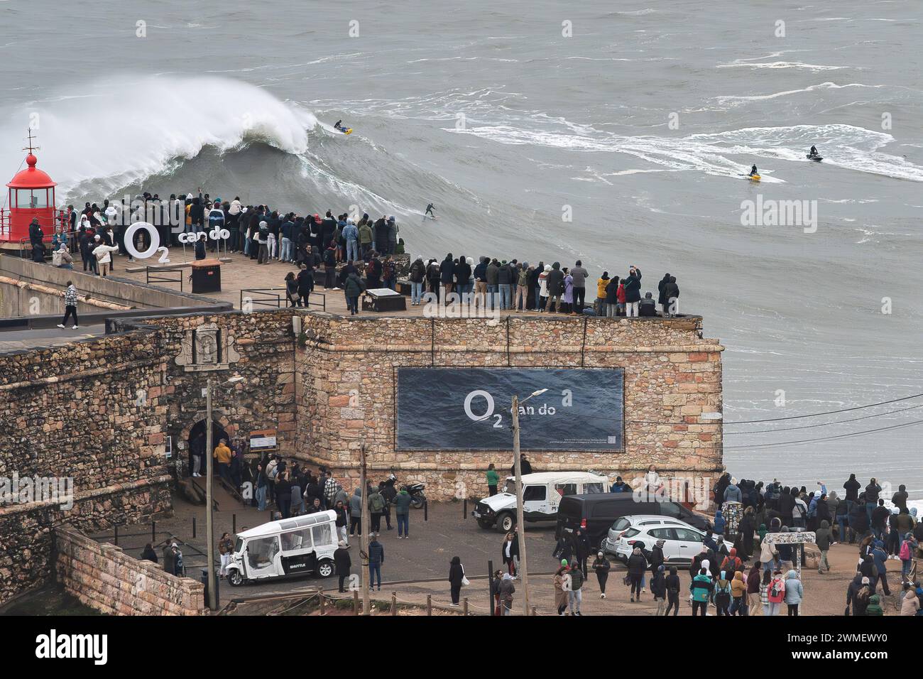 Le persone in cima al faro di Nazaré osservano un surfista che cattura un'onda gigante. Venerdì 23 e sabato 24 febbraio, la spiaggia portoghese di Praia do Norte a Nazaré è stata colpita da una violenta tempesta che ha creato onde giganti per le quali questo luogo è famoso in tutto il mondo. Le condizioni meteorologiche epiche hanno creato onde alte oltre 20 metri. Credito: SOPA Images Limited/Alamy Live News Foto Stock