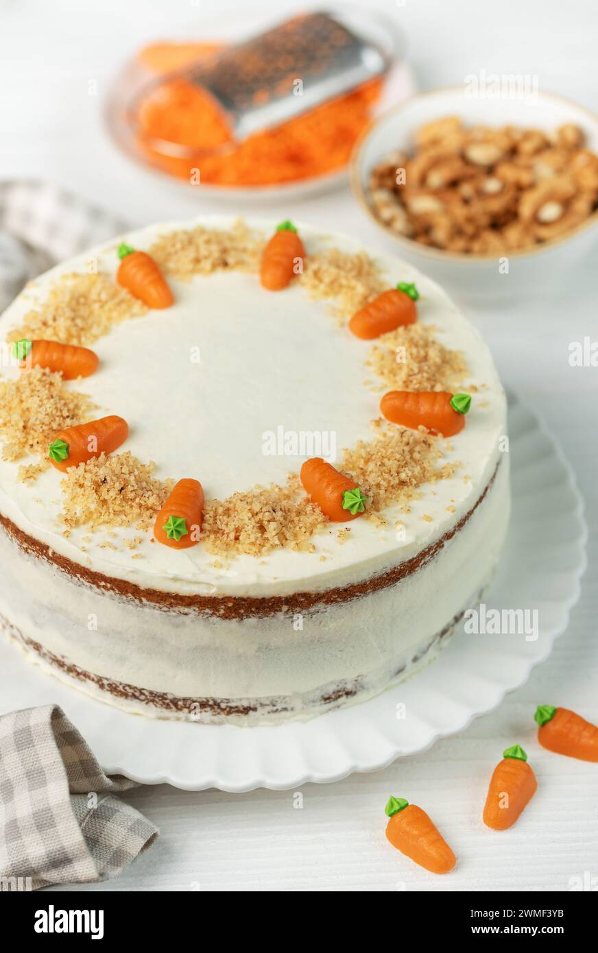 Torta di carote fatta in casa con noci, ghiacciata con formaggio spalmabile. Dolce dolce. Piatto con deliziosa torta di carote Foto Stock