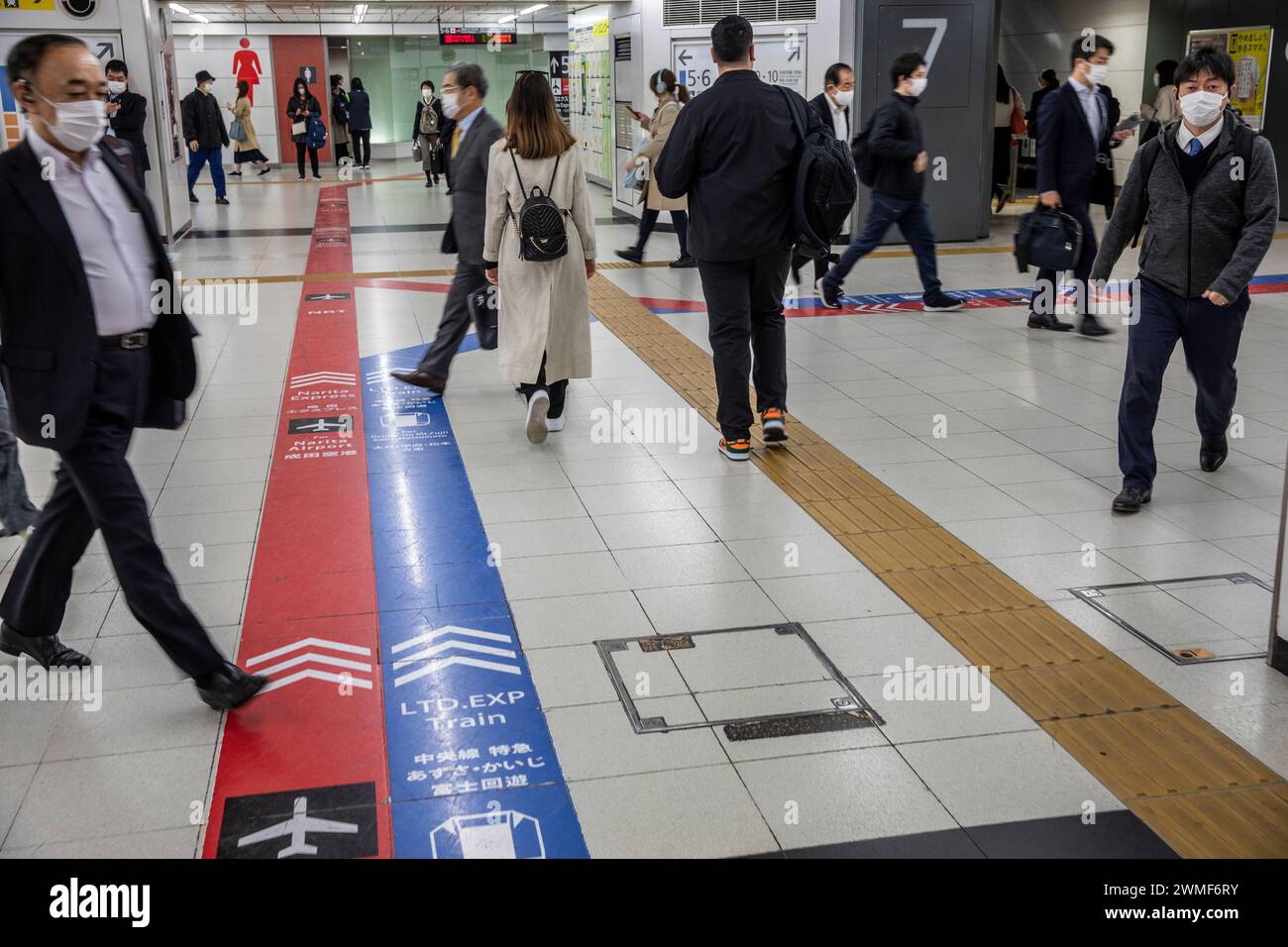 La stazione ferroviaria di Tokyo della metropolitana, le marcature rosse e blu indicano la direzione per i treni espressi NRT Narita Express in rosso e blu, Giappone, 2023 Foto Stock