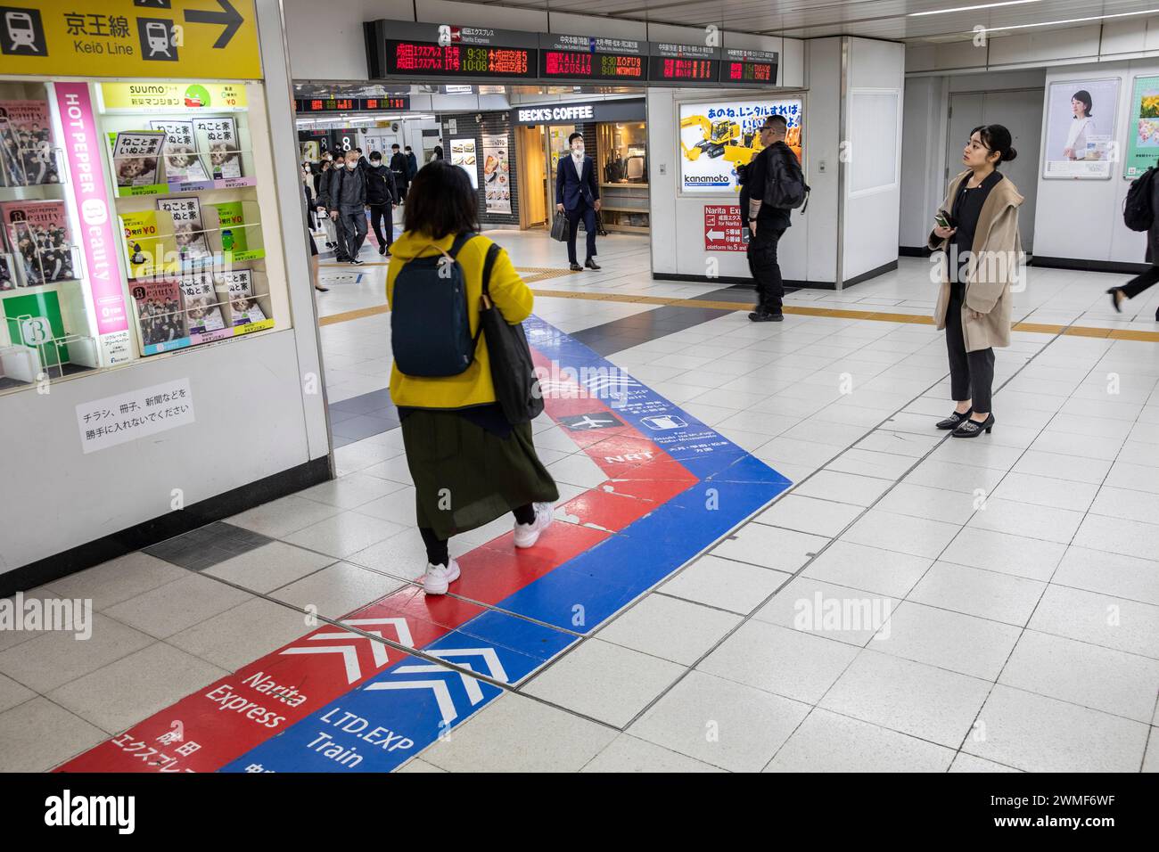 La stazione ferroviaria di Tokyo della metropolitana, le marcature rosse e blu indicano la direzione per i treni espressi NRT Narita Express in rosso e blu, Giappone, 2023 Foto Stock